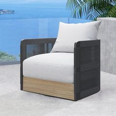 an outdoor lounge chair with white cushions and a view of the ocean in the background