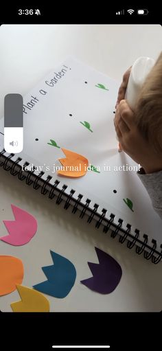 a child is writing on a notebook with colorful arrows