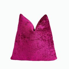 a pink velvet pillow on a white background