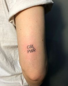 a woman with a tattoo on her arm that says girl power in the middle of it