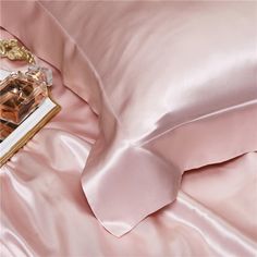 a pink satin bed spread with an open box of chocolates on it