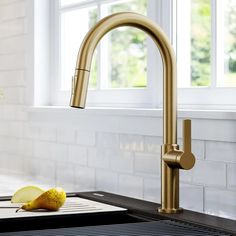 a golden faucet on a kitchen counter next to an apple