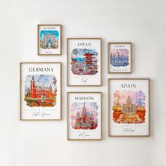 four framed pictures hang on the wall in front of a white wall with european landmarks