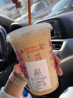 a person holding up a cup of coffee in their hand with a sticker on it