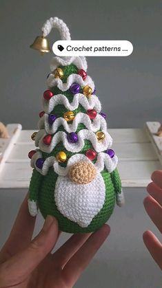 someone is holding up a crocheted christmas tree ornament