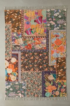 a patchwork wall hanging with flowers on it