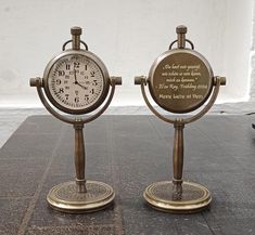 two small clocks sitting on top of a table