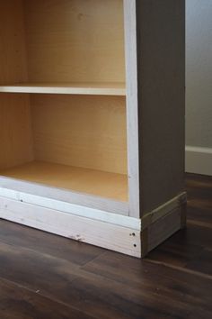 an empty bookcase sitting on top of a hard wood floor