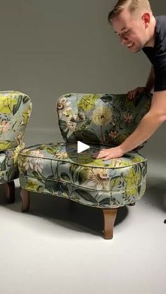 a man is bending over an upholstered chair