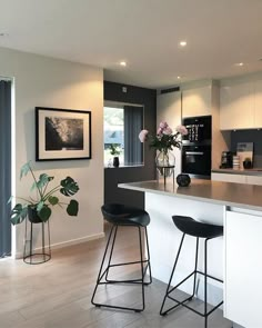 a kitchen with two bar stools next to an island