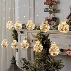 a christmas tree with lights hanging from it's branches and decorations on the mantle