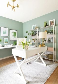 a white desk sitting on top of a hard wood floor next to a wall mounted shelf