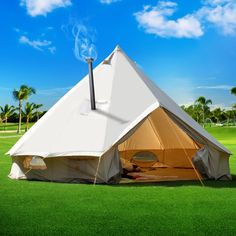 a large white tent sitting on top of a lush green field next to palm trees