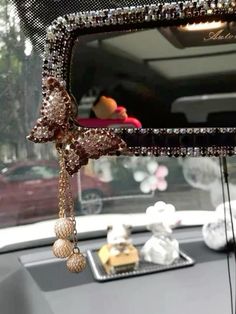 the rear view mirror of a car with beads hanging from it