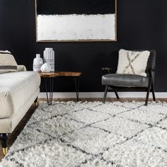 a living room with black walls and white rugs