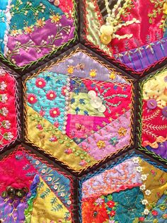 a close up of a patchwork quilt with many different colors and designs on it