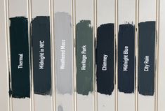 four different shades of paint sitting on the side of a wall