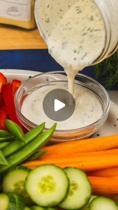 the dressing is being poured over vegetables and cucumbers