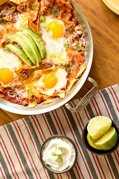 a dish with eggs, avocado and sour cream in it on a table