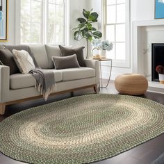 a living room with a couch, chair and rug in front of a fire place