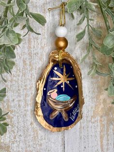 a christmas ornament hanging on a wooden wall with green leaves and starfish