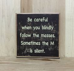 a wooden sign that says, be careful when you bindly follow the masses sometimes the m is silent