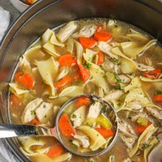 a pot filled with chicken noodle soup on top of a table