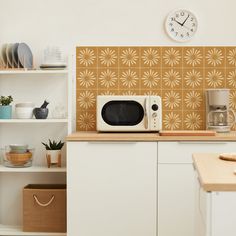 a white microwave oven sitting on top of a counter next to a wooden cutting board