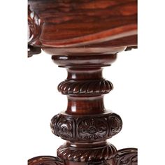 an ornate wooden table with carvings on the top and bottom, against a white background