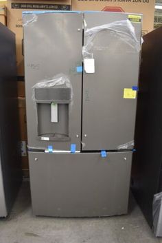 two refrigerators are stacked on top of each other in a store with tags attached to them