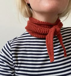 a woman with blonde hair wearing a red scarf around her neck and looking up at the sky