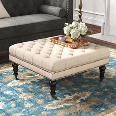 a living room with a couch, chair and coffee table on top of a rug