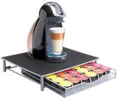 an espresso machine on top of a tray with cupcakes