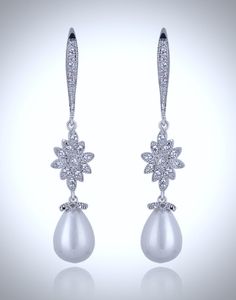 Lightweight and elegant, this beautiful pair of earrings features 12mm teardrop pearls in an iridescent white color accented by clear cubic zirconia for extra sparkle. Overall length of the earring is 50mm (approx. 2"). Hypoallergenic - lead, nickel and cadmium free. This elegant pair of earrings will add glamour to any wedding dress or formal ensemble. Cubic Zirconia Bridal Earrings, Iridescent Color, Iridescent White, Pearl Jewelry Wedding, Bridal Earrings, Accent Colors, Pearl Jewelry, White Color, Wedding Jewelry