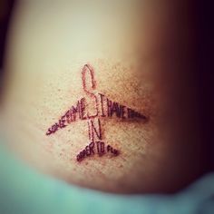 a small airplane tattoo on the side of a woman's ribcage is shown