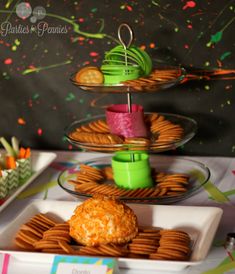 three tiered trays filled with cookies and crackers on top of a table