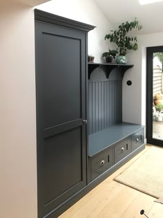 a room that has some shelves and plants on the top shelf in front of it