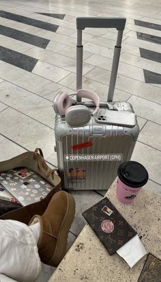 luggage sitting on the ground next to a bag and some other items in front of it