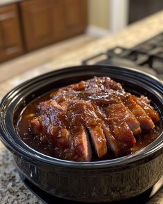 a bowl filled with meat sitting on top of a counter