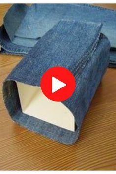 an open pair of jeans sitting on top of a wooden floor next to a piece of cloth