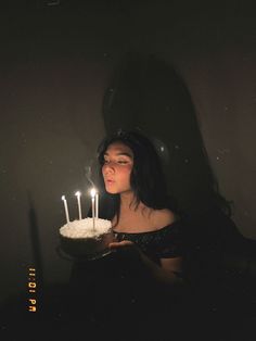 a woman holding a cake with lit candles