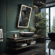 a bathroom with green walls and black counter top, gold trim on the mirror above the sink