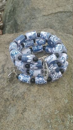 a bracelet with blue and white beads on top of a rock