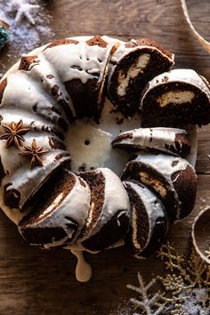 a chocolate bundt cake with icing and cinnamon stars on top, sitting on a wooden table