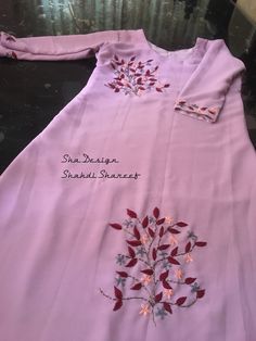 a pink dress with embroidered flowers on it