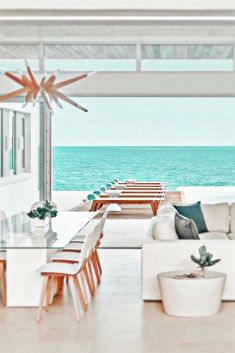 a living room filled with furniture next to the ocean