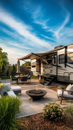 an rv is parked next to a fire pit with chairs and tables in the foreground