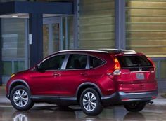 a red honda cr - v parked in front of a building