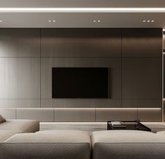 a living room with couches and a flat screen tv mounted on the wall above it