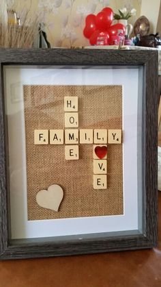 a frame with scrabbles and hearts on it